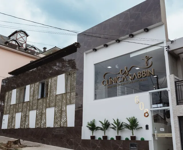 Fachada da Clínica Sabbin, com revestimento de pedra e o nome da clínica