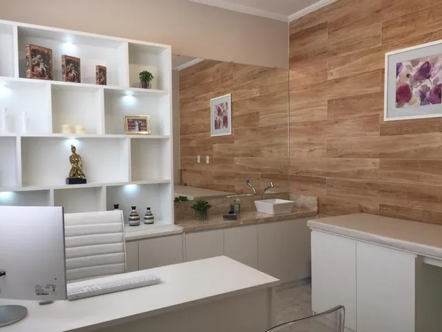 Sala de atendimento com estante branca e painel de madeira